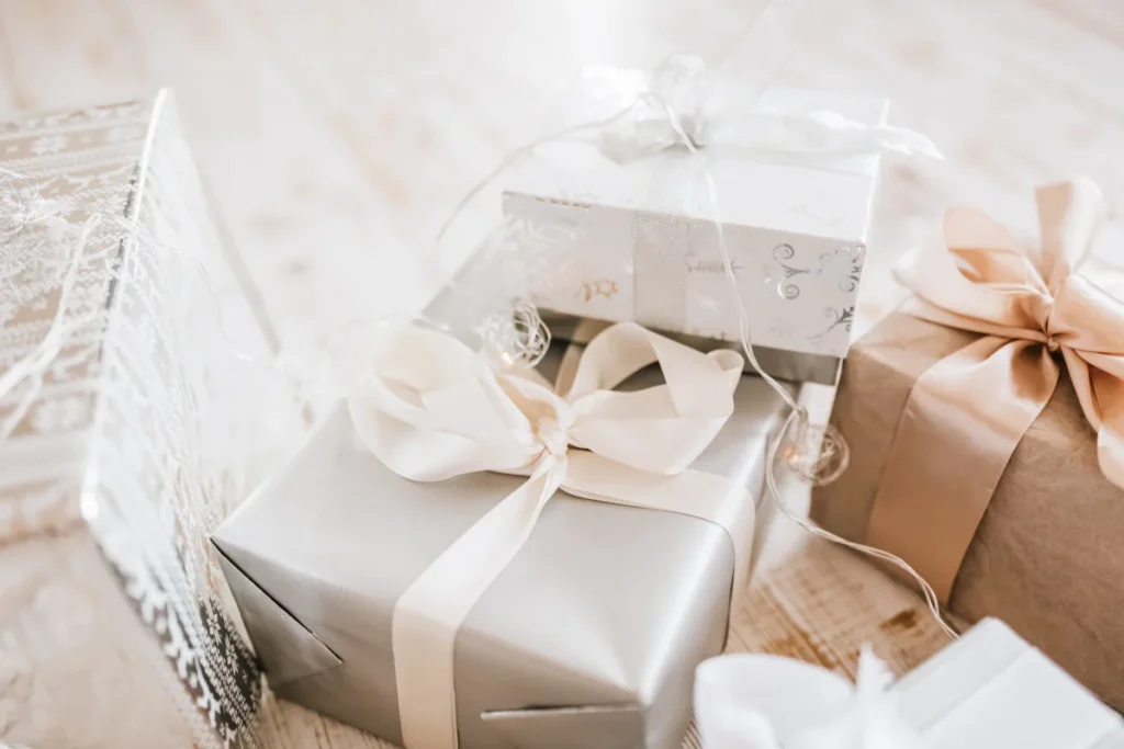 Presentes embrulhados com papel prateado, branco e marrom com fitas elegantes em tons neutros