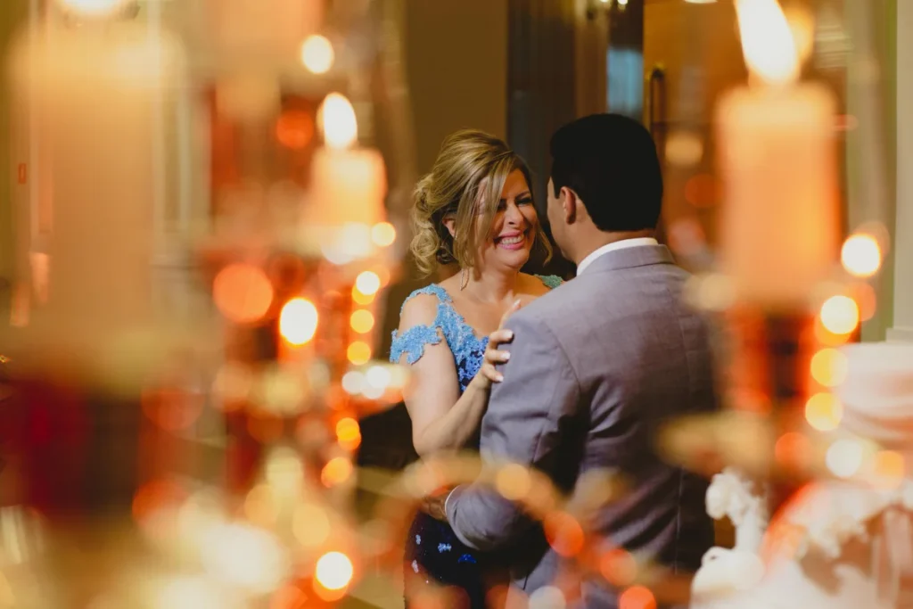 Casal dançando em ambiente com iluminação suave e velas acesas