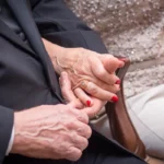 Bodas de casamento: tudo para você comemorar cada ano juntos Casal idoso de mãos dadas, mostrando anel dourado e unhas vermelhas, com roupas formais