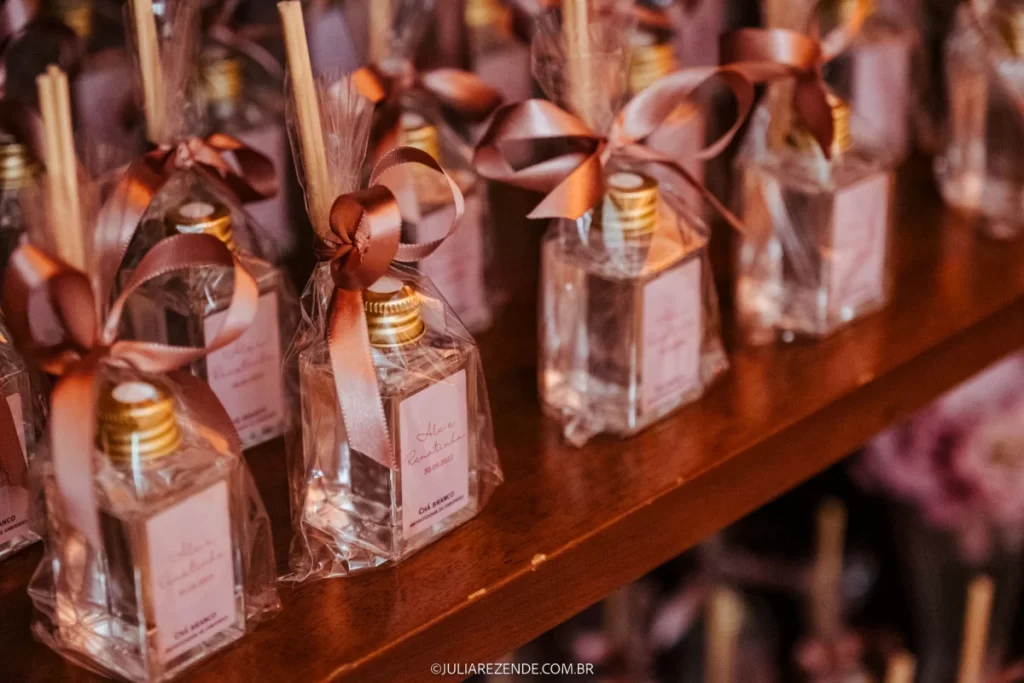 Lembrancinhas de casamento com mini garrafas de chá branco embaladas com laços de fita marrom