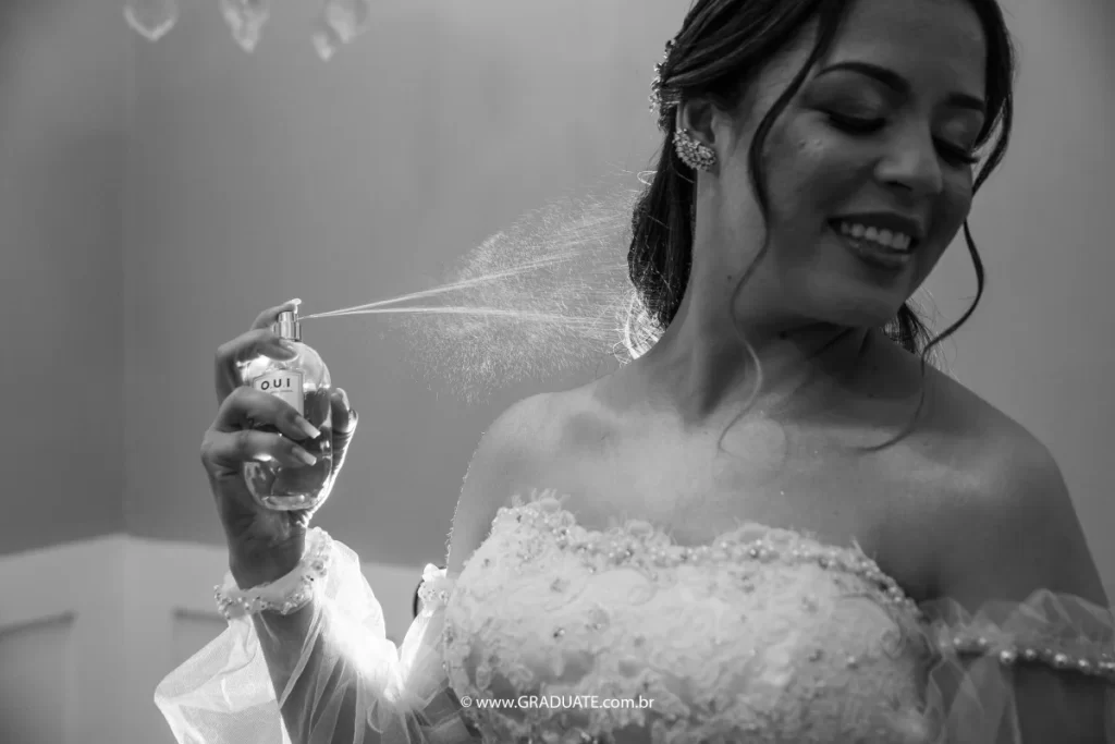 Noiva aplicando perfume em preto e branco