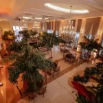 Veja 4 tipos de espaço de eventos corporativos em São Paulo Salão de festas elegante decorado com árvores artificiais e iluminação sofisticada ideal para eventos especiais