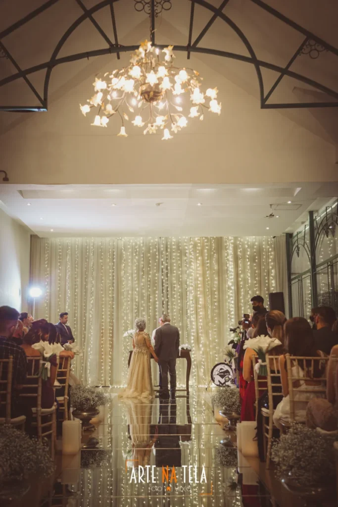 Casal de idosos em cerimônia de bodas de casamento elegante com decoração de luzes pisca-pisca e lustre floral