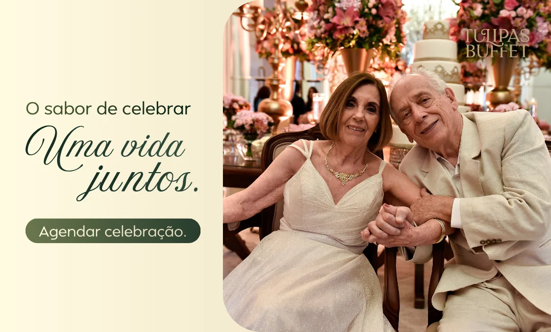 Casal idoso sorridente celebrando em festa de bodas elegante com decoração floral e bolo de casamento