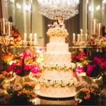 Checklist de casamento: passo a passo até o grande dia Bolo de casamento com cinco andares e flores no topo com boneco dos noivos